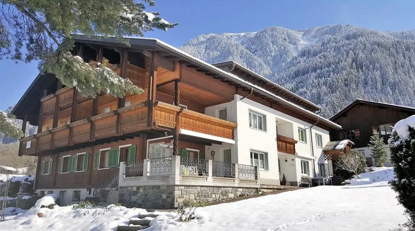 Haus Gostanova im Winter: Holzbalkone, Schnee und Berge